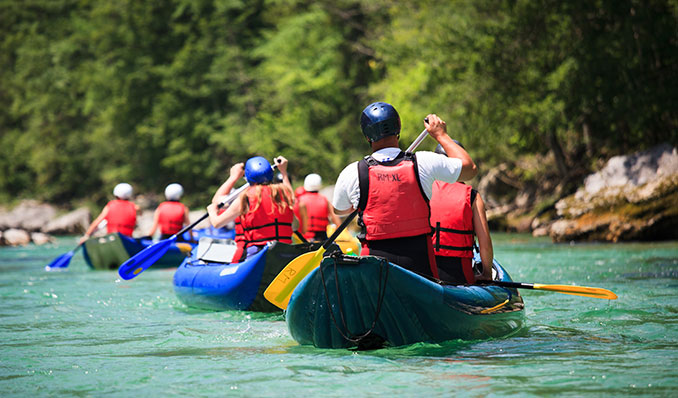 Boys and girls canoeing on a river